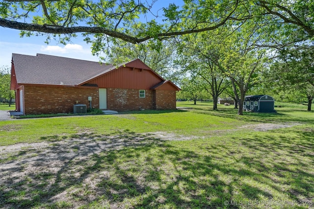 1510 Bowden Pl, Fort Gibson, OK 74434 - view of side of property featuring central AC unit, brick siding, a yard, and a shingled roof