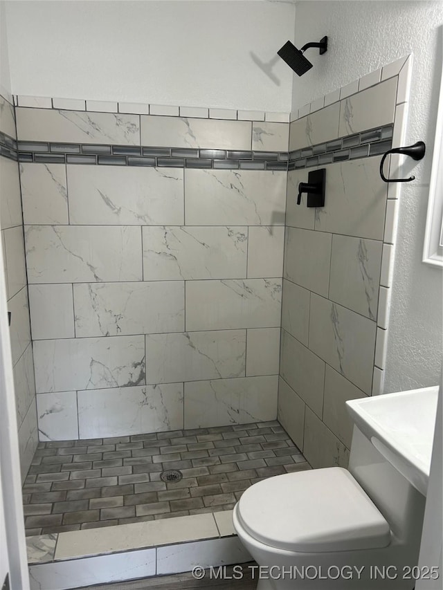 4613 N Main St E, Tulsa, OK 74115 - full bathroom with a stall shower, toilet, and a textured wall
