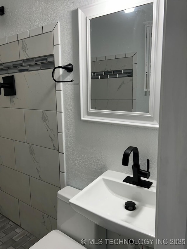 4613 N Main St E, Tulsa, OK 74115 - bathroom featuring a sink, a textured wall, toilet, and tiled shower