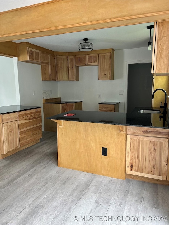 4613 N Main St E, Tulsa, OK 74115 - kitchen featuring a sink, light wood-type flooring, a peninsula, and dark countertops