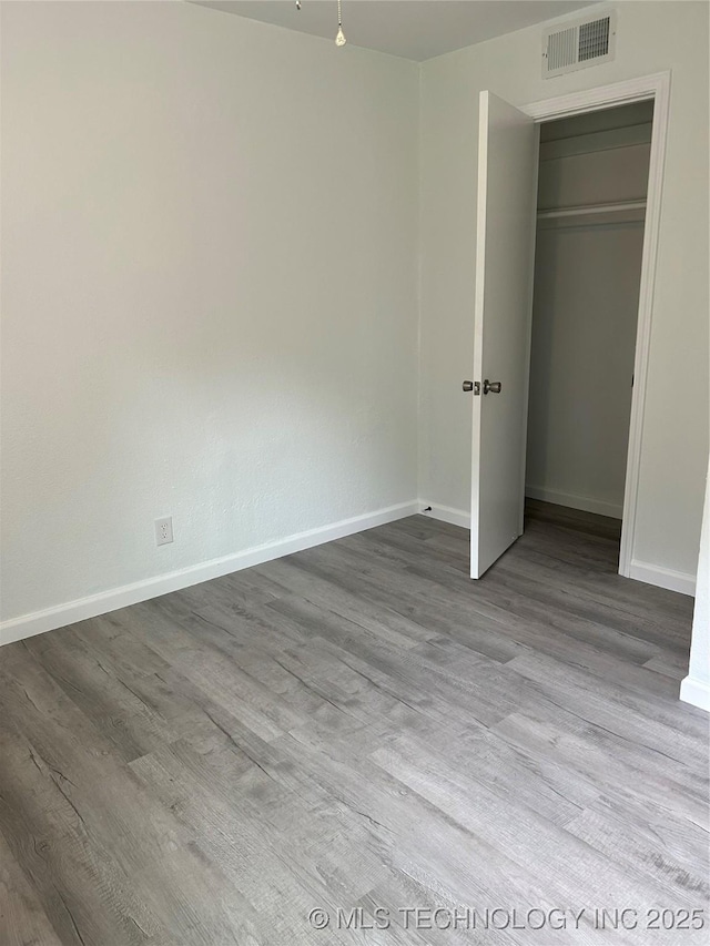 4613 N Main St E, Tulsa, OK 74115 - unfurnished bedroom featuring baseboards, wood finished floors, and a closet