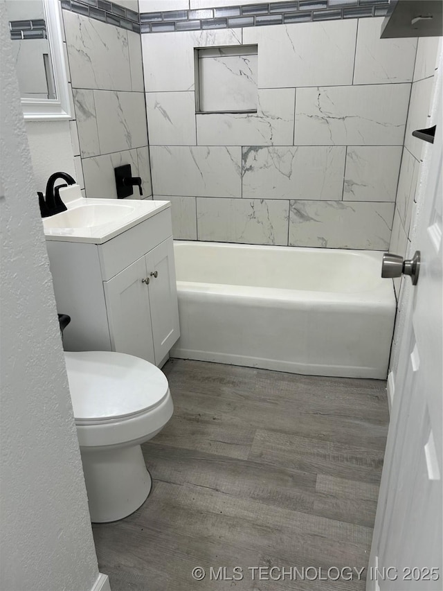 4613 N Main St E, Tulsa, OK 74115 - bathroom featuring vanity, wood finished floors, toilet, and washtub / shower combination
