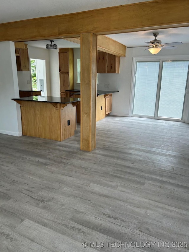4613 N Main St E, Tulsa, OK 74115 - kitchen with dark countertops, a peninsula, a breakfast bar, and light wood-type flooring