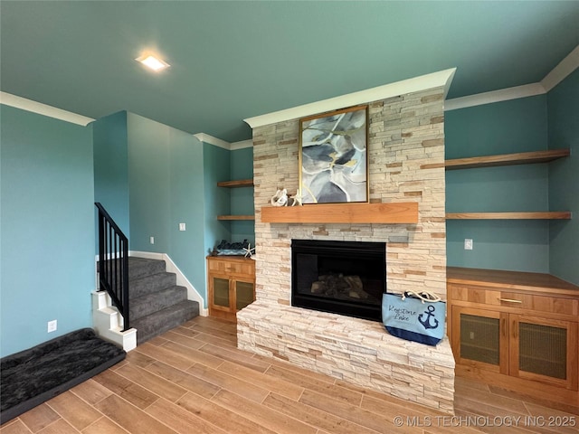 659 Sleepy Hollow Ln, Cleveland, OK 74020 - unfurnished living room featuring wood tiled floors, a fireplace, crown molding, baseboards, and stairs