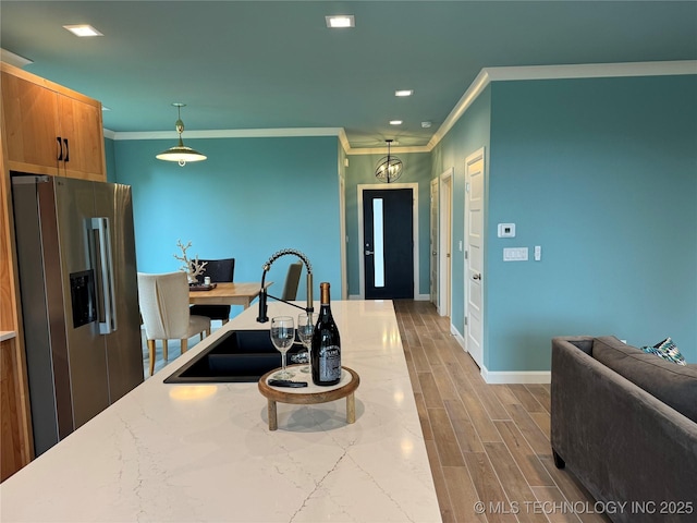659 Sleepy Hollow Ln, Cleveland, OK 74020 - kitchen featuring stainless steel refrigerator with ice dispenser, a sink, crown molding, hanging light fixtures, and baseboards