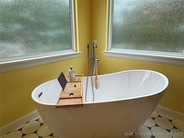 659 Sleepy Hollow Ln, Cleveland, OK 74020 - bathroom with tile patterned floors, a freestanding bath, and healthy amount of natural light