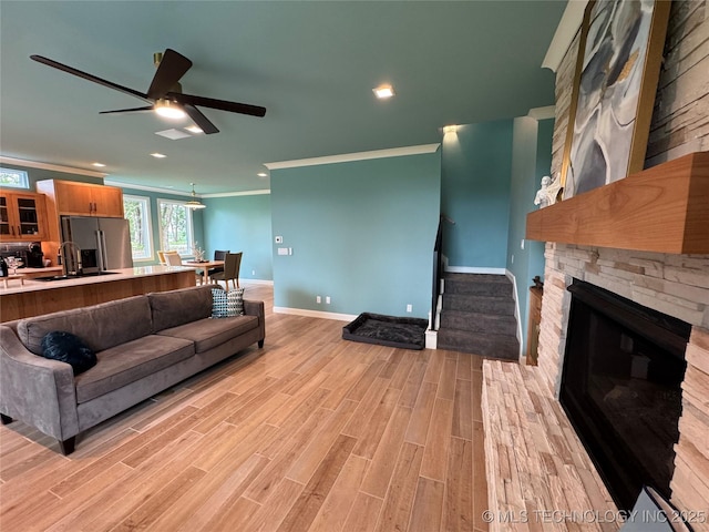 659 Sleepy Hollow Ln, Cleveland, OK 74020 - living area featuring crown molding, a fireplace, light wood-style flooring, a ceiling fan, and baseboards