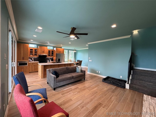 659 Sleepy Hollow Ln, Cleveland, OK 74020 - living area featuring crown molding, baseboards, stairs, a ceiling fan, and light wood finished floors