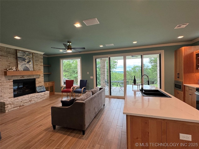 659 Sleepy Hollow Ln, Cleveland, OK 74020 - living area featuring crown molding, light wood-style flooring, a fireplace, recessed lighting, and ceiling fan