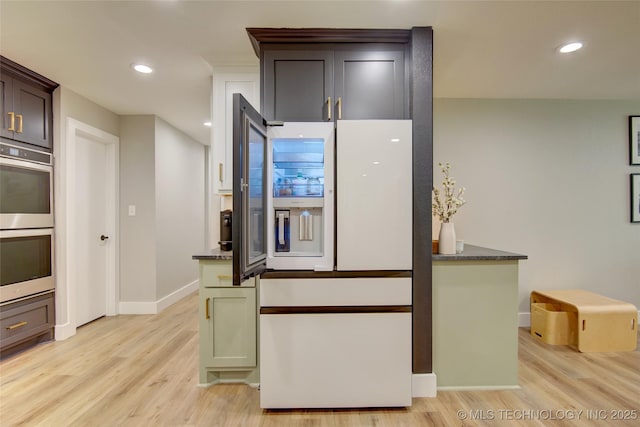 5132 S Atlanta Ave, Tulsa, OK 74105 - kitchen with double oven, light wood-type flooring, baseboards, recessed lighting, and white fridge with ice dispenser