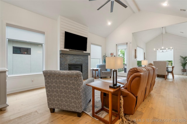 1228 W 85th Ct S, Tulsa, OK 74132 - living room with a fireplace, light wood-style flooring, a chandelier, and a ceiling fan
