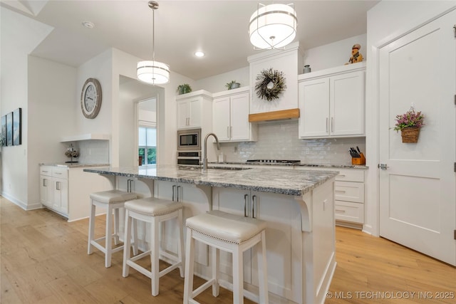 1228 W 85th Ct S, Tulsa, OK 74132 - kitchen featuring stainless steel appliances, backsplash, light wood-style flooring, white cabinets, and recessed lighting