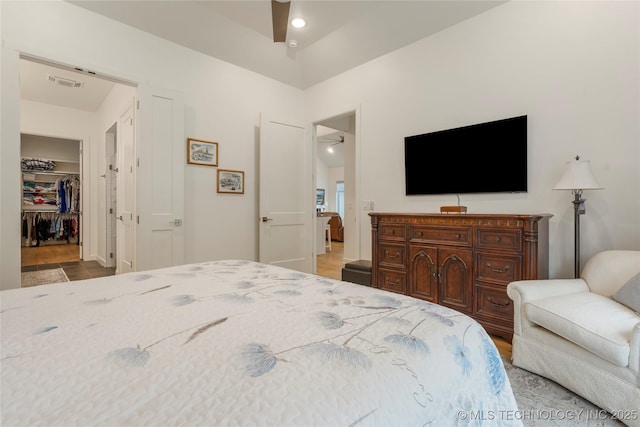 1228 W 85th Ct S, Tulsa, OK 74132 - bedroom featuring a walk in closet and wood finished floors