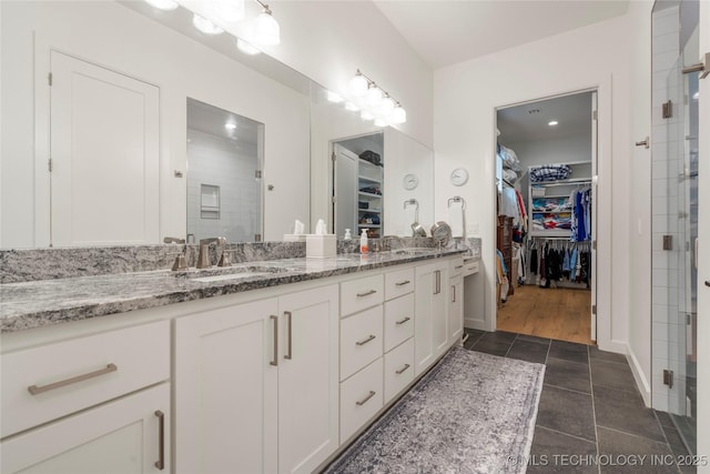 1228 W 85th Ct S, Tulsa, OK 74132 - bathroom with double vanity, a spacious closet, and a stall shower
