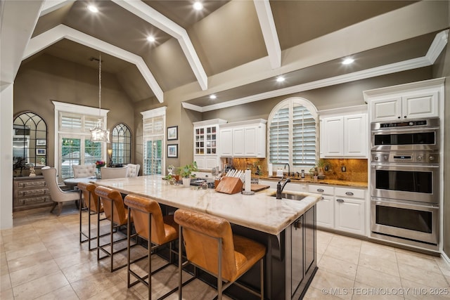 6317 E 110th St, Tulsa, OK 74137 - kitchen with white cabinets, recessed lighting, stainless steel double oven, light stone countertops, and decorative backsplash