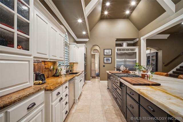 6317 E 110th St, Tulsa, OK 74137 - kitchen with arched walkways, white cabinetry, high vaulted ceiling, a sink, and beverage cooler
