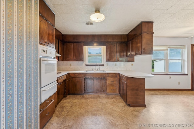 405 Dom Giaudrone, Mcalester, OK 74501 - kitchen with a warming drawer, oven, a sink, light countertops, and tasteful backsplash