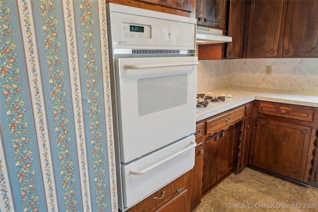 405 Dom Giaudrone, Mcalester, OK 74501 - kitchen featuring a warming drawer, white appliances, under cabinet range hood, light countertops, and tasteful backsplash