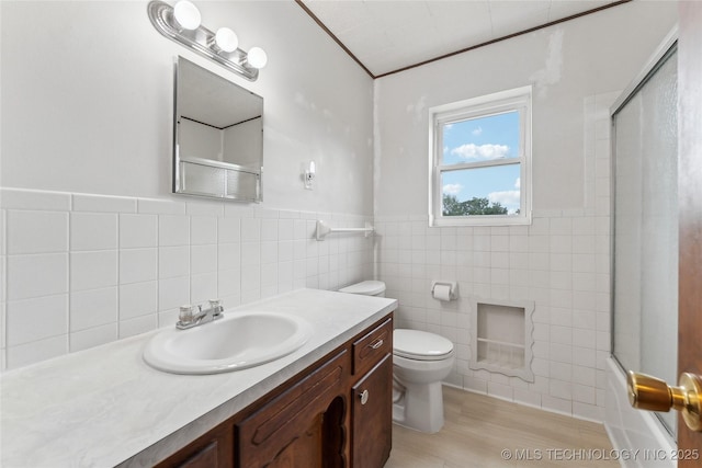 405 Dom Giaudrone, Mcalester, OK 74501 - bathroom with tile walls, vanity, toilet, wood finished floors, and enclosed tub / shower combo