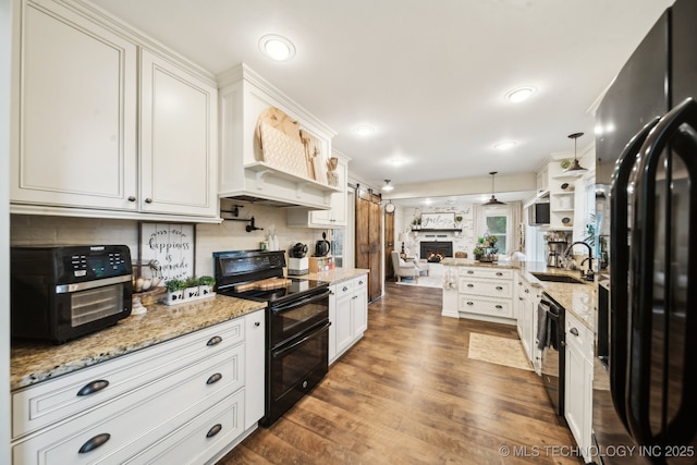 719 W Teel Rd, Sapulpa, OK 74066 - kitchen with black appliances, a sink, open floor plan, dark wood-style flooring, and white cabinetry
