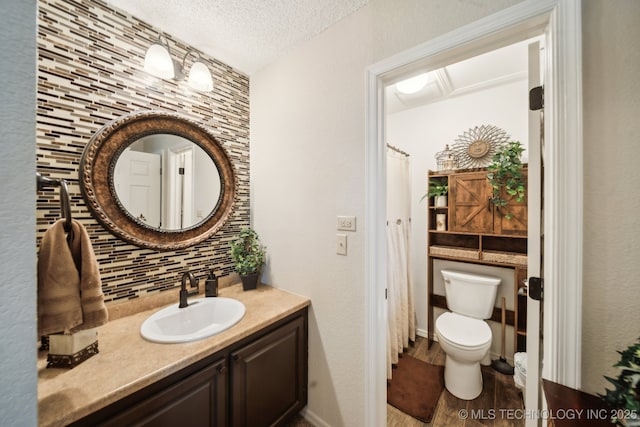 719 W Teel Rd, Sapulpa, OK 74066 - full bathroom with tasteful backsplash, toilet, vanity, wood finished floors, and a textured ceiling