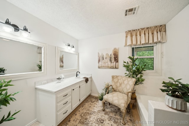 719 W Teel Rd, Sapulpa, OK 74066 - bathroom featuring vanity, a textured ceiling, a bath, and baseboards