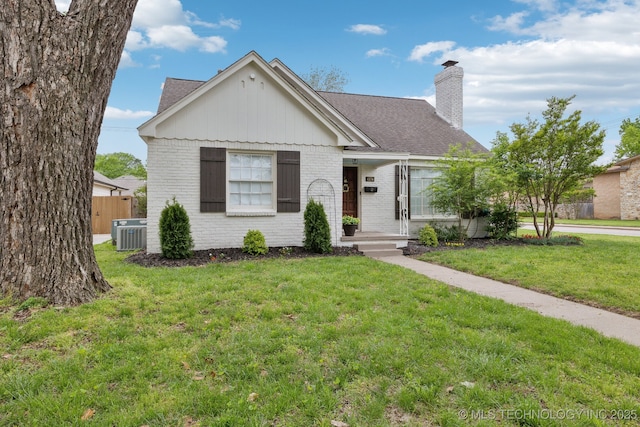 4104 S Owasso Ave, Tulsa, OK 74105 - view of front of house with central AC, a chimney, brick siding, and roof with shingles