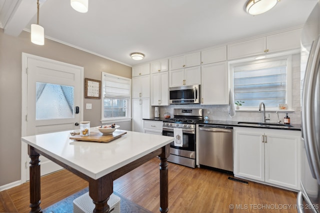 4104 S Owasso Ave, Tulsa, OK 74105 - kitchen with stainless steel appliances, a sink, tasteful backsplash, white cabinets, and healthy amount of natural light