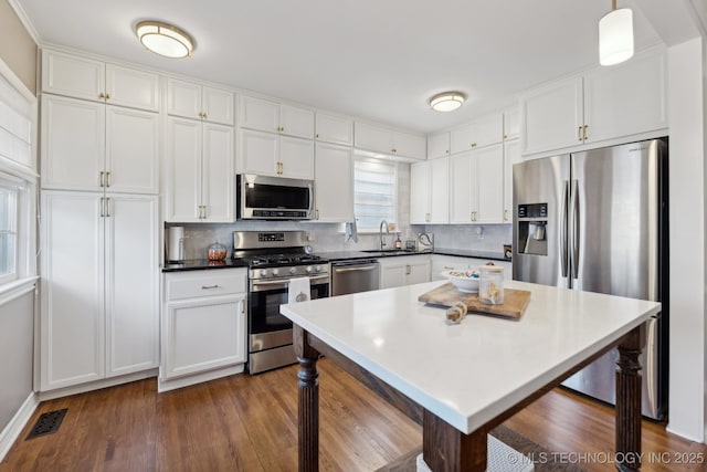 4104 S Owasso Ave, Tulsa, OK 74105 - kitchen featuring stainless steel appliances, backsplash, white cabinets, and a sink