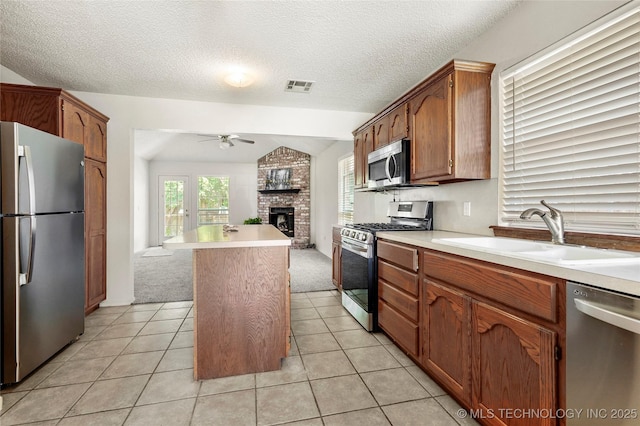 1309 N Willow Ave, Broken Arrow, OK 74012 - kitchen featuring appliances with stainless steel finishes, a sink, ceiling fan, open floor plan, and light countertops