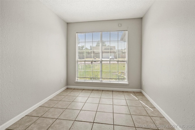 1309 N Willow Ave, Broken Arrow, OK 74012 - unfurnished room with light tile patterned floors, a textured wall, a textured ceiling, and baseboards
