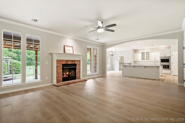 13041 E 67th St, Broken Arrow, OK 74012 - unfurnished living room with plenty of natural light, a ceiling fan, light wood-style flooring, and ornamental molding