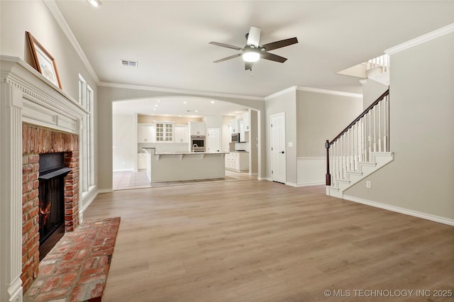 13041 E 67th St, Broken Arrow, OK 74012 - unfurnished living room with a ceiling fan, a fireplace, ornamental molding, light wood-type flooring, and stairway