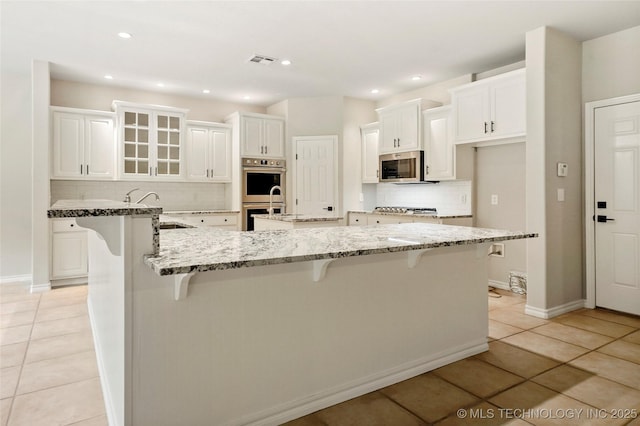 13041 E 67th St, Broken Arrow, OK 74012 - kitchen with stainless steel appliances, a sink, light tile patterned flooring, a large island, and backsplash