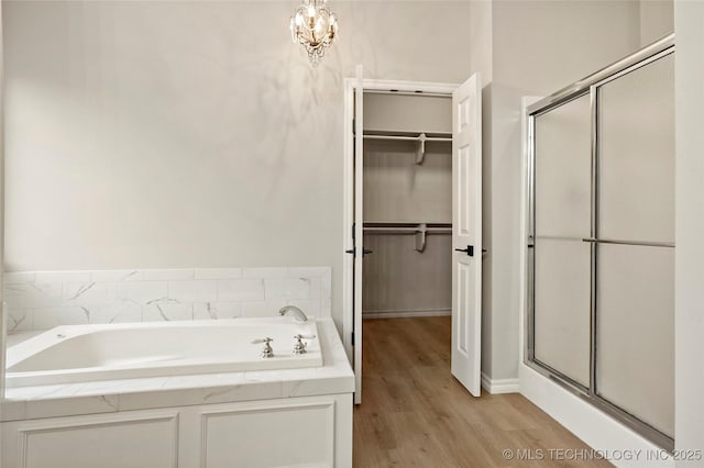 13041 E 67th St, Broken Arrow, OK 74012 - bathroom with a shower stall, wood finished floors, a bath, a spacious closet, and baseboards