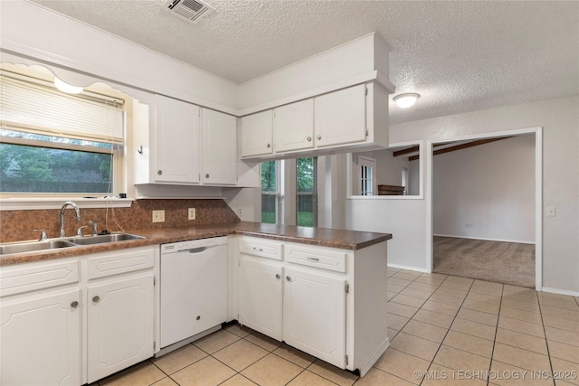 901 S Lions Ave, Broken Arrow, OK 74012 - kitchen featuring white dishwasher, a sink, a textured ceiling, a peninsula, and light colored carpet