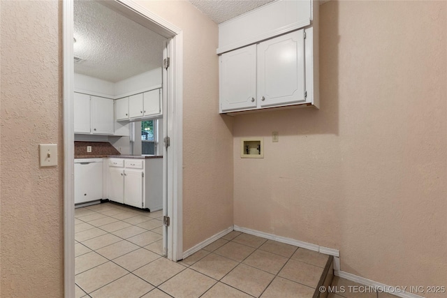 901 S Lions Ave, Broken Arrow, OK 74012 - laundry room with a textured ceiling, washer hookup, cabinet space, light tile patterned floors, and baseboards