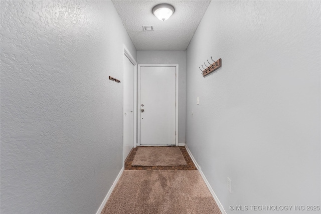 901 S Lions Ave, Broken Arrow, OK 74012 - doorway to outside with carpet flooring, a textured ceiling, and baseboards