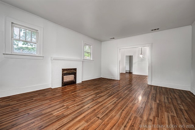 316 K St SW, Ardmore, OK 73401 - unfurnished living room with wood finished floors, a brick fireplace, and baseboards