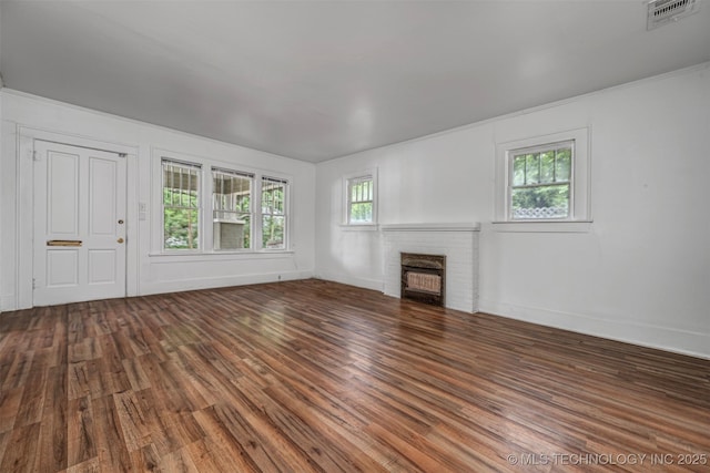 316 K St SW, Ardmore, OK 73401 - unfurnished living room featuring wood finished floors, a brick fireplace, and baseboards