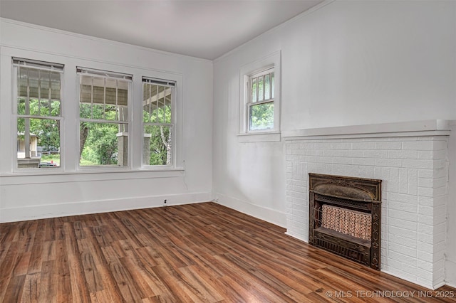 316 K St SW, Ardmore, OK 73401 - unfurnished living room featuring ornamental molding, a brick fireplace, wood finished floors, and baseboards