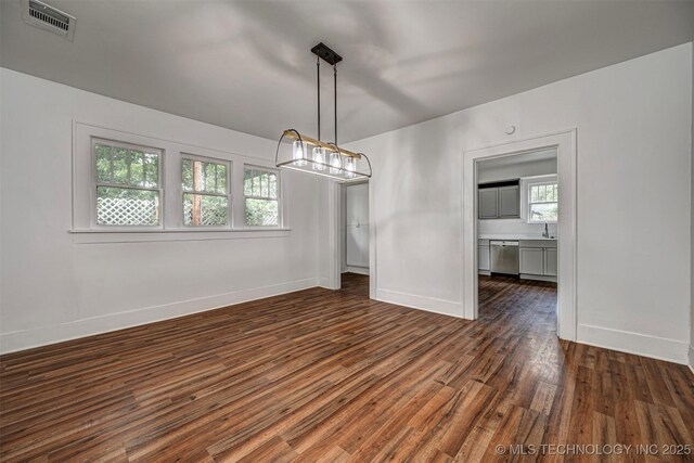 316 K St SW, Ardmore, OK 73401 - unfurnished room with a chandelier, dark wood finished floors, baseboards, and a sink