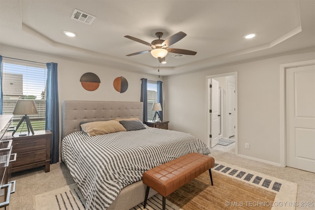 7506 E 87th Pl, Owasso, OK 74055 - carpeted bedroom with a tray ceiling, multiple windows, recessed lighting, ceiling fan, and connected bathroom