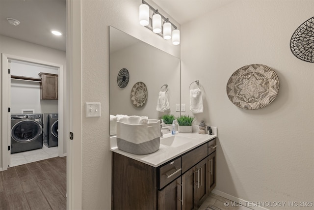 7506 E 87th Pl, Owasso, OK 74055 - bathroom with separate washer and dryer, vanity, and wood finished floors