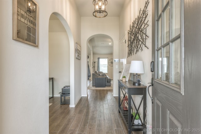 7506 E 87th Pl, Owasso, OK 74055 - foyer featuring arched walkways, dark wood finished floors, and a chandelier