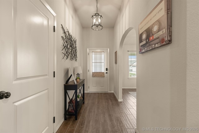 7506 E 87th Pl, Owasso, OK 74055 - foyer entrance featuring arched walkways, a chandelier, and dark wood-type flooring
