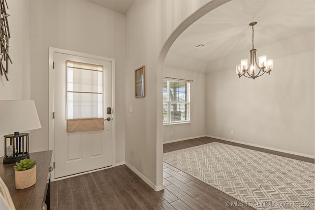 7506 E 87th Pl, Owasso, OK 74055 - foyer entrance with arched walkways, dark wood-style flooring, and a chandelier