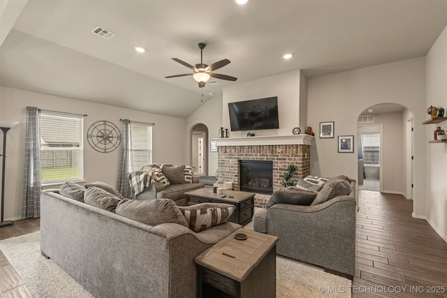 7506 E 87th Pl, Owasso, OK 74055 - living area featuring arched walkways, wood finished floors, ceiling fan, a fireplace, and vaulted ceiling