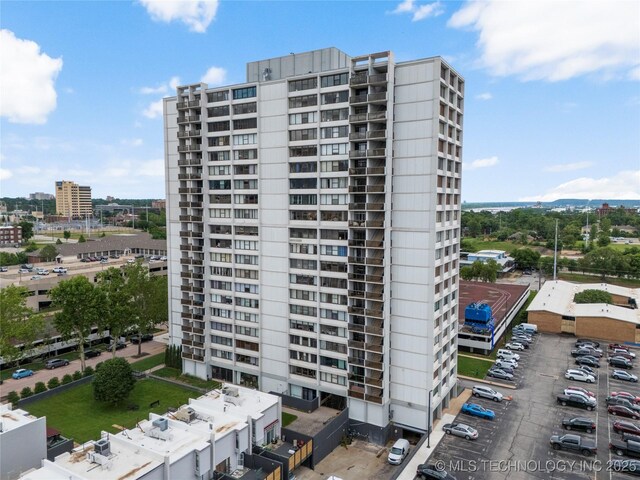 450 W 7th St Unit 1101, Tulsa, OK 74119 - view of apartment building / complex featuring uncovered parking and a city view