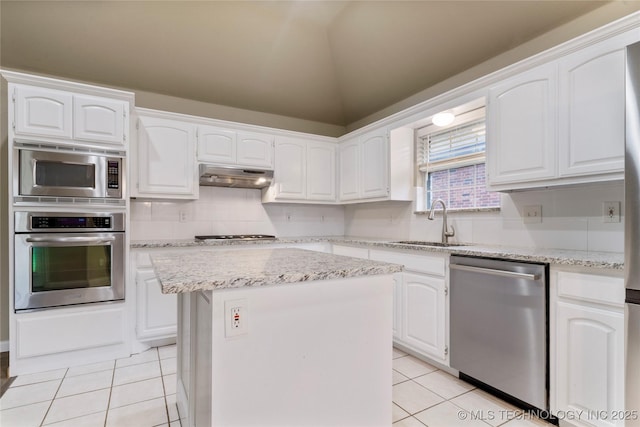 4309 W College St, Broken Arrow, OK 74012 - kitchen with stainless steel appliances, light tile patterned floors, a sink, under cabinet range hood, and white cabinetry